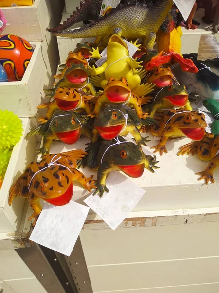 fake smiling rubber frogs and toads for sale as games in a children\'s shop display
