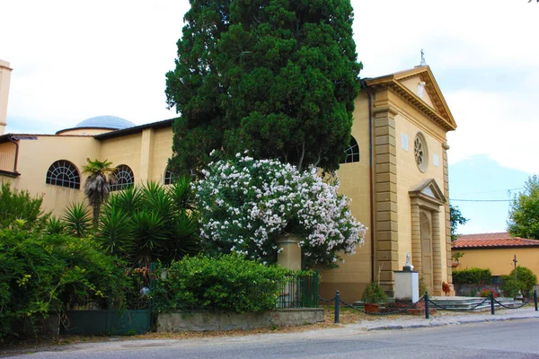 トスカーナの木々や植物の間の道路上のVecchianoの教会の側ファサードの壁 — ストック写真