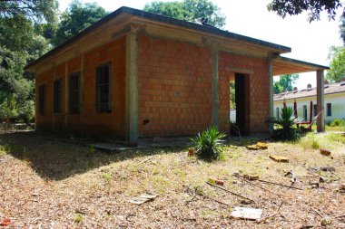 Tamamlanmamış kırmızı tuğla ve beton bir evde inşaat işi. Kırsal alanda mimari stil ayrıntıları var.