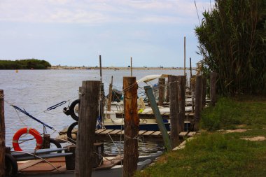 Toskana 'daki yeşil ormanda küçük teknelerin bataklığa battığı bir nehirde rustik marina.