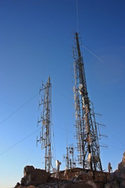 İletişim, telekomünikasyon ve televizyon antenleri, dağların tepesindeki kayaların arasına yerleştirilmiş..