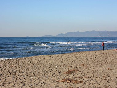 İtalyan kışının güneşli bir gününde Versilia 'nın kumlu kumlu sahilinde dinlendirici yürüyüşler.