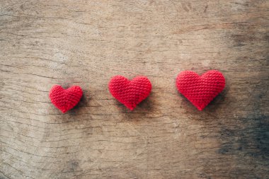 Kalp ahşap arka plan üzerinde kırmızı iplikten yapılmış. Sevgililer günü konsepti.