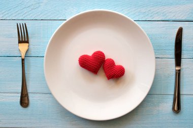 Kalp beyaz plaka üzerinde kırmızı iplikyapılmış . Sevgililer günü konsepti.