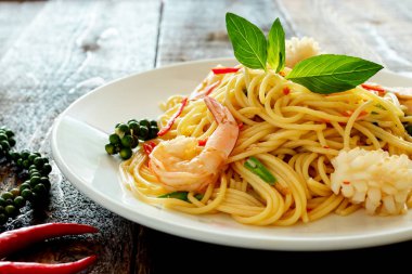 tabakta deniz ürünleri ile baharatlı spagetti.