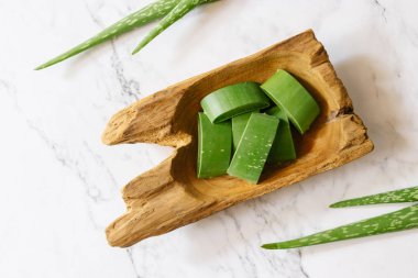 Ahşap kase taze aloe vera yaprakları üst görünümü. spa arka plan konsepti.