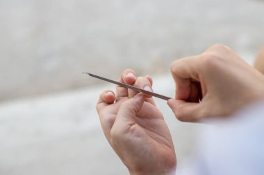 Tırnak törpüsüyle manikür yapan bir kadın..