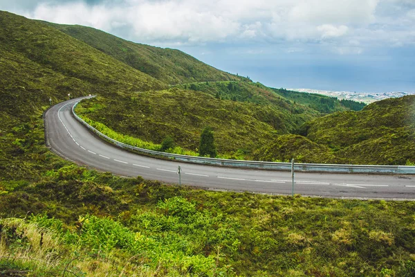 Droga prowadzi przez zielony krajobraz na wyspie Sao Miguel, Azory, Portugalia — Zdjęcie stockowe