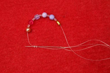 Bir tanga üzerinde renkli boncuk çekimi el bir closeup