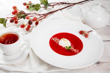 Dondurma ve nane ile çilek çorbası. Püresi çilek vanilyalı dondurma ile tepesinde nane yaprakları ile süslenmiş. Karışık çilek. Berry tatlı