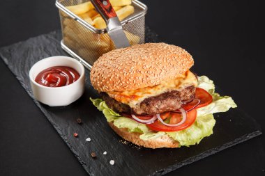 Siyah arka planda taze lezzetli bir burger.