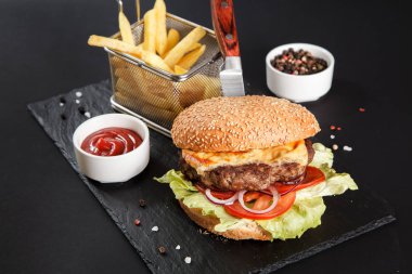 Siyah arka planda taze lezzetli bir burger.