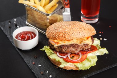 Siyah arka planda taze lezzetli bir burger.