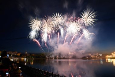 Su üzerinde gece gökyüzünde güzel piroteknik havai fişek gösterisi. Kutlama.