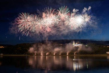 Su üzerinde gece gökyüzünde güzel piroteknik havai fişek gösterisi. Kutlama.