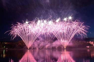 Su üzerinde gece gökyüzünde güzel piroteknik havai fişek gösterisi. Kutlama.
