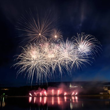 Su üzerinde gece gökyüzünde güzel piroteknik havai fişek gösterisi. Kutlama.