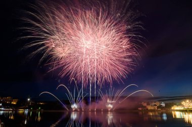 Su üzerinde gece gökyüzünde güzel piroteknik havai fişek gösterisi. Kutlama.