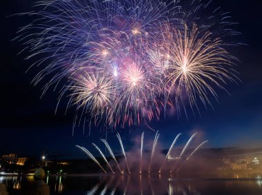 Su üzerinde gece gökyüzünde güzel piroteknik havai fişek gösterisi. Kutlama.