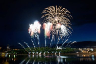 Su üzerinde gece gökyüzünde güzel piroteknik havai fişek gösterisi. Kutlama.