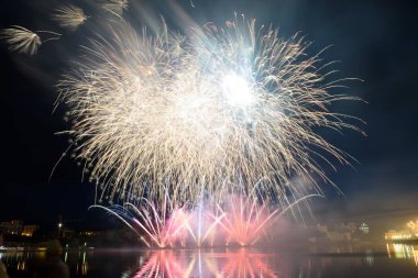 Su üzerinde gece gökyüzünde güzel piroteknik havai fişek gösterisi. Kutlama.