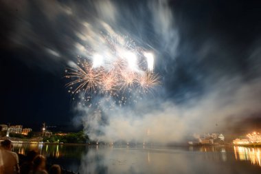 Su üzerinde gece gökyüzünde güzel piroteknik havai fişek gösterisi. Kutlama.