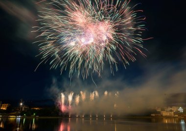Su üzerinde gece gökyüzünde güzel piroteknik havai fişek gösterisi. Kutlama.