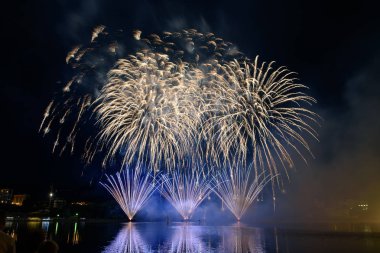 Su üzerinde gece gökyüzünde güzel piroteknik havai fişek gösterisi. Kutlama.