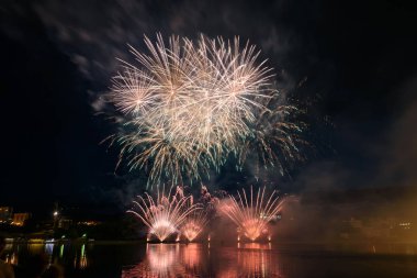 Su üzerinde gece gökyüzünde güzel piroteknik havai fişek gösterisi. Kutlama.