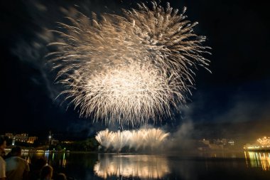 Su üzerinde gece gökyüzünde güzel piroteknik havai fişek gösterisi. Kutlama.