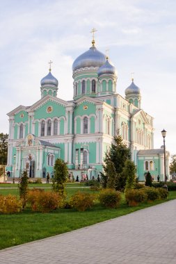 Kutsal Üçlü Üçlü Serafim-Dalgıç Manastırı 'ndaki (Diveevo, Nizhny Novgorod bölgesi, Rusya) Trinity Katedrali' nin manzarası, bulutlu bir yaz akşamında bulutlu bir gökyüzünün arka planında yer alan kubbeler ve haçlar