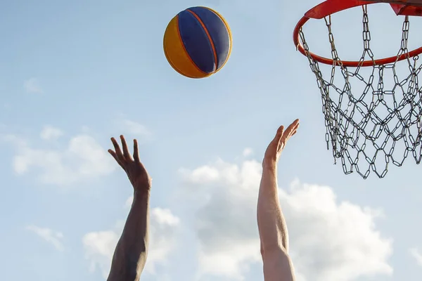 Black and white human hands fighting for the ball during a basketball game. Concept sport against racism