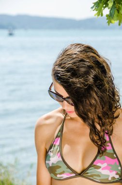 Bikini ve lake banyo, güneş gözlüğü giyen genç kadın