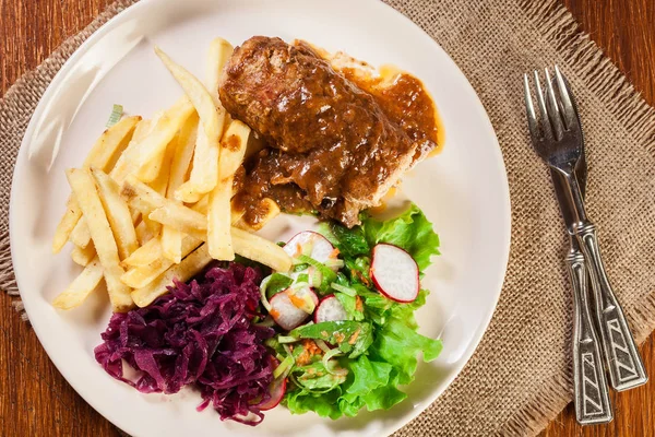 プレートにサラダとフライド ポテトの豚肉ロール — ストック写真