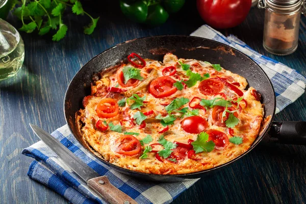 由鸡蛋 辣椒粉 西红柿 奶酪和辣椒制成的弗里塔塔 放在木制桌子上的锅里 意大利菜 — 图库照片