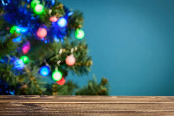 与节日圣诞树在背景中的木桌 把重点放在桌子上 — 图库照片