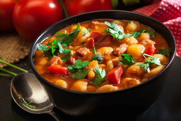 Vit Bönsoppa Med Potatis Tomater Paprika Och Bacon Svart Keramikskål — Stockfoto