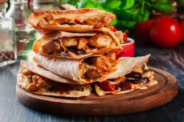Stack of quesadillas with chicken, sausage chorizo and red pepper served with salsa. Mexican cuisine. Side view clipart