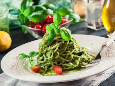 Pasta spaghetti with homemade basil pesto sauce on white plate clipart