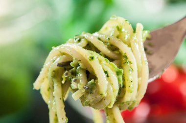 Close-up of pasta spaghetti with homemade basil pesto sauce on white plate. Top view clipart
