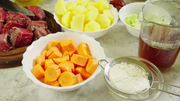 Ingredients for preparing Irish stew: beef, potatoes, carrots and herbs. Traditional St Patrick's day dish — Stock Footage Ingredients Preparing Irish Stew Beef Potatoes Carrots Herbs Traditional Patrick Video Clip