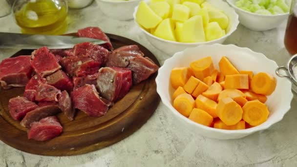 Ingredients for preparing Irish stew: beef, potatoes, carrots and herbs. Traditional St Patrick's day dish — Stock Footage Ingredients Preparing Irish Stew Beef Potatoes Carrots Herbs Traditional Patrick Stock Footage