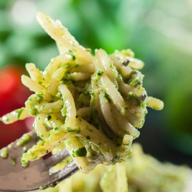 Close-up of pasta spaghetti with homemade basil pesto sauce on white plate. Top view clipart