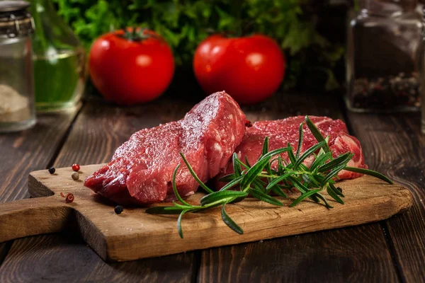 Fresh raw beef steak sirloin with rosemary on cutting board