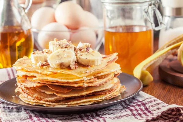 Thin pancakes with banana, walnuts and honey for breakfast