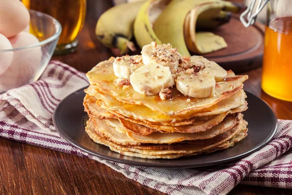 Thin pancakes with banana, walnuts and honey for breakfast