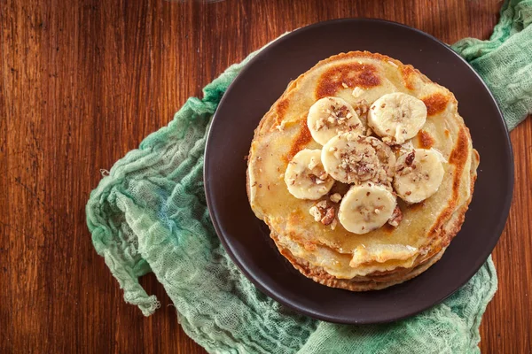 Thin pancakes with banana, walnuts and honey for breakfast