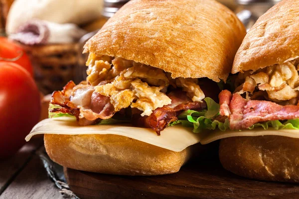 Sanduíche Ciabatta Com Bacon Defumado Ovos Uma Tábua Corte — Fotografia de Stock