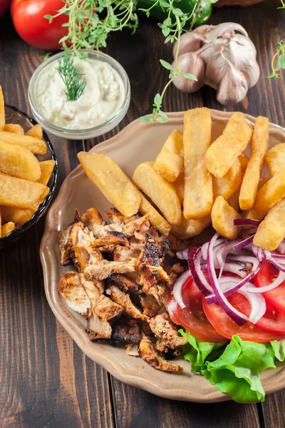 Greek gyros dish with french fries and vegetables