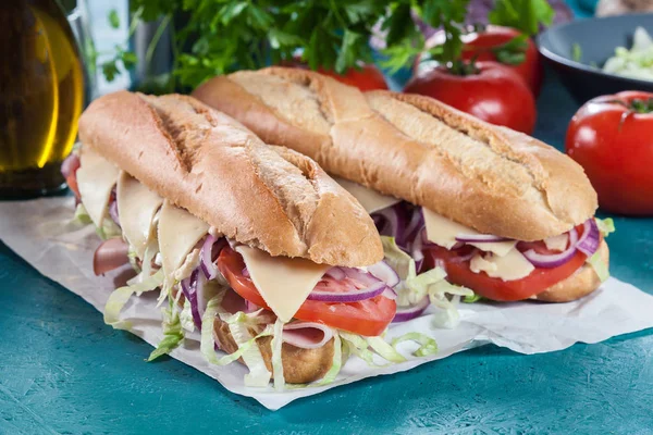 Submarine sandwiches with ham, cheese and vegetables — Stock Photo, Image